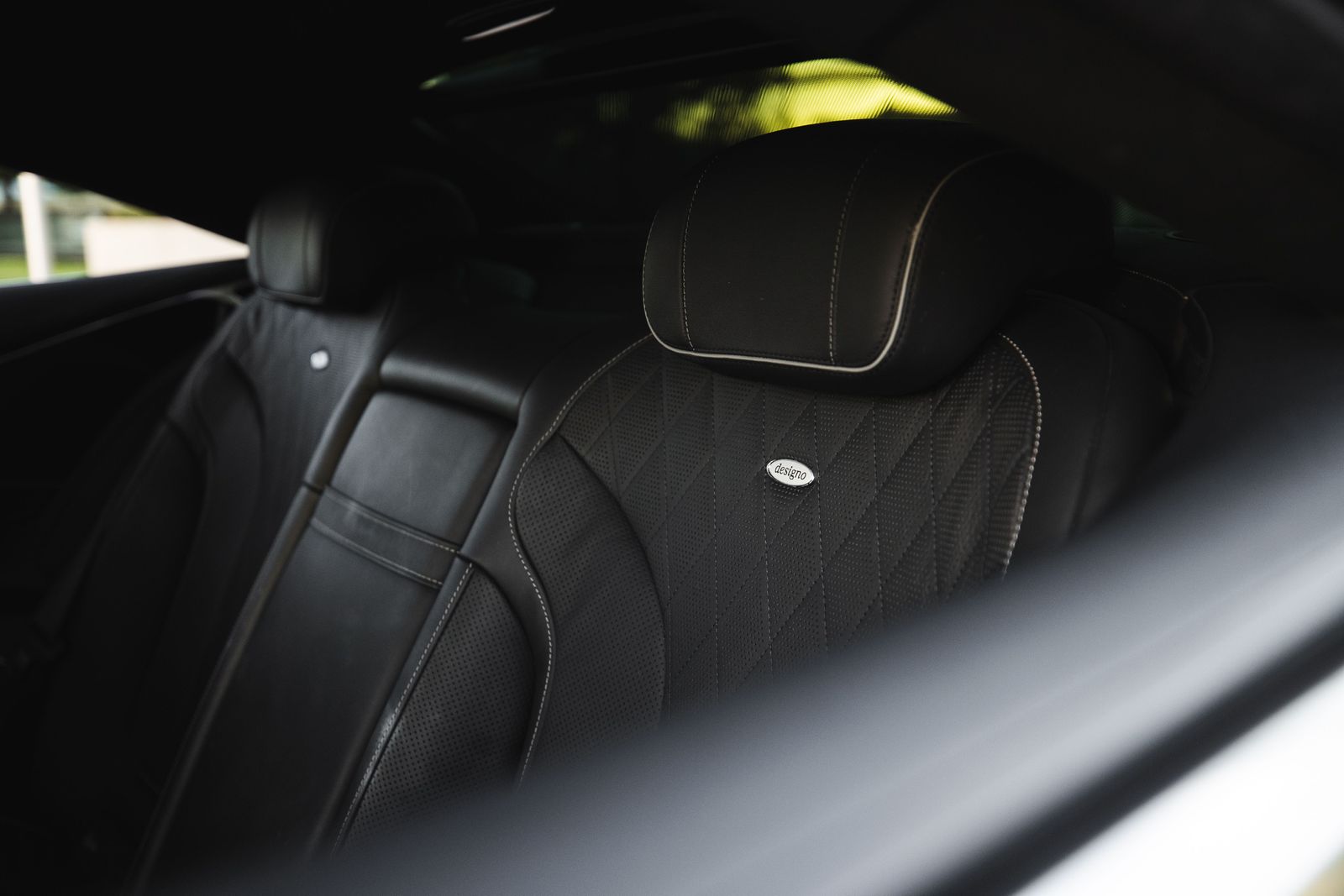 The rear cabin of a luxury car with dark leather seating